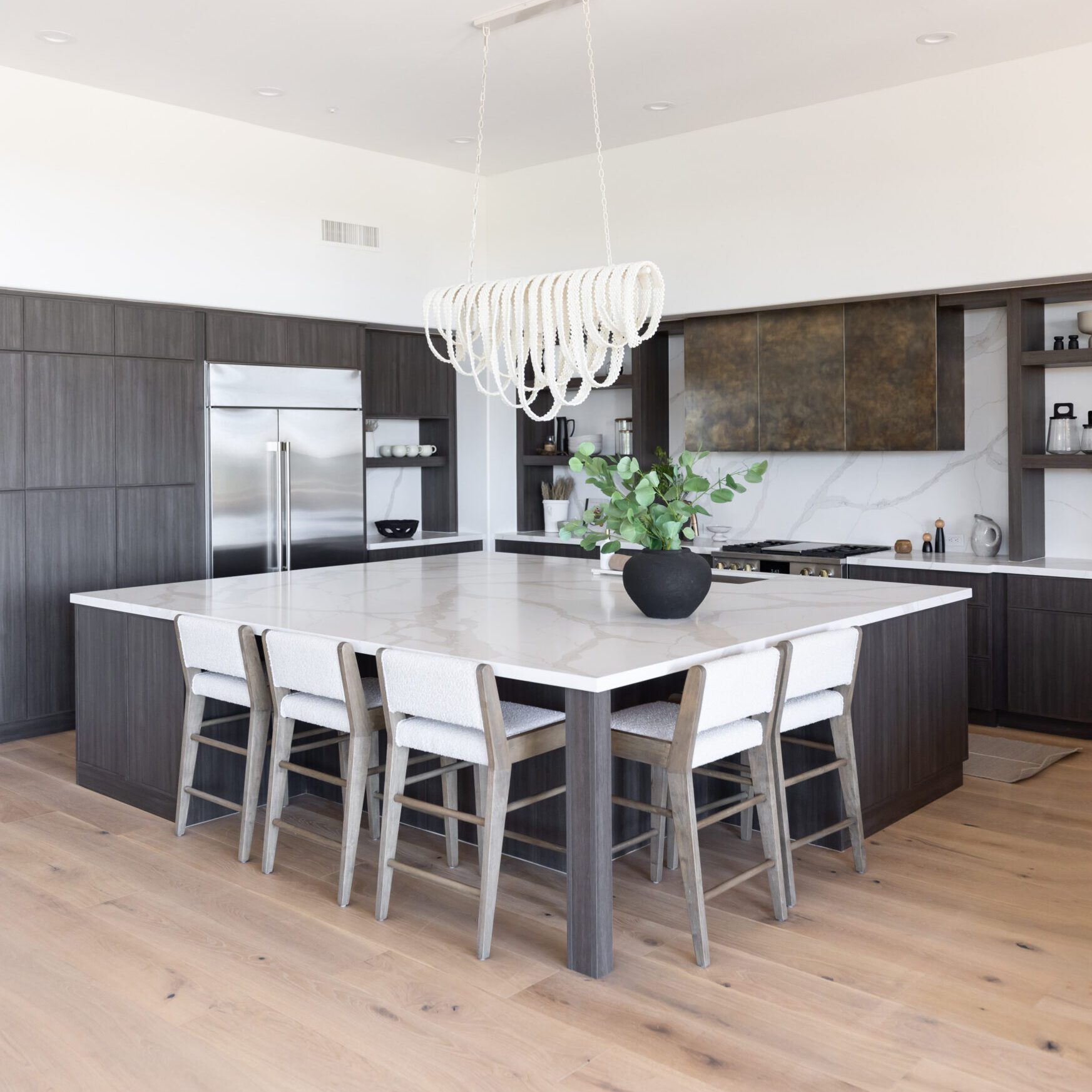 Contemporary kitchen with sleek finishes and island Kitchen with island, dark cabinets, and white counters