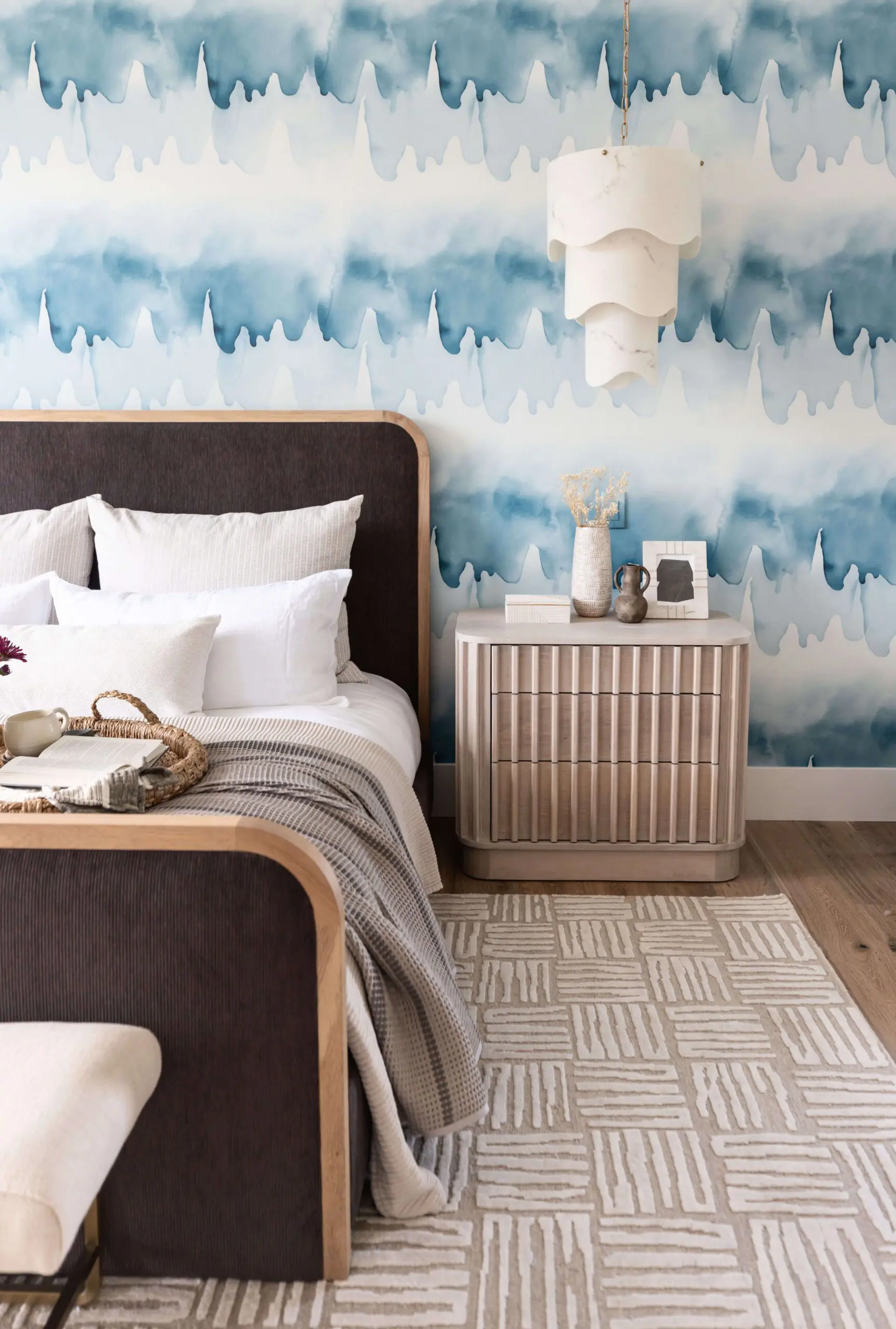 a serene bedroom with light wood furniture and blue wallpaper